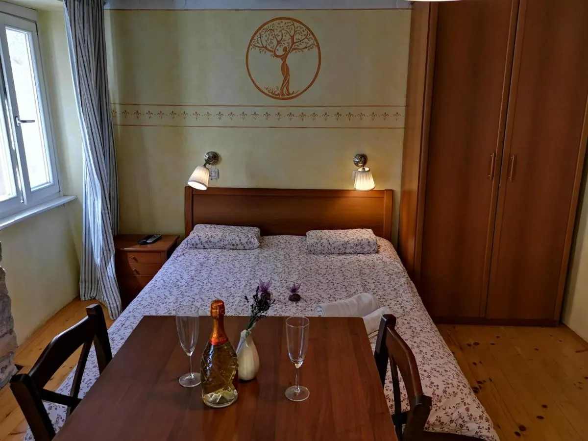Apartma Tierra: miza pred posteljo in drevo na steni